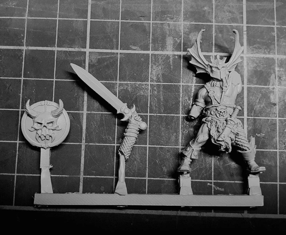 Model on a sprue, as supplied - three component parts (shield, sword arm, body.