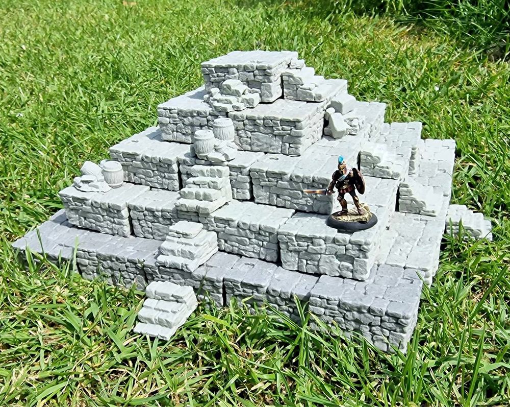 Large resin model of a stone ziggurat with partially collapsed staircases and a lone adventurer cautiously exploring one of itsa lower levels.