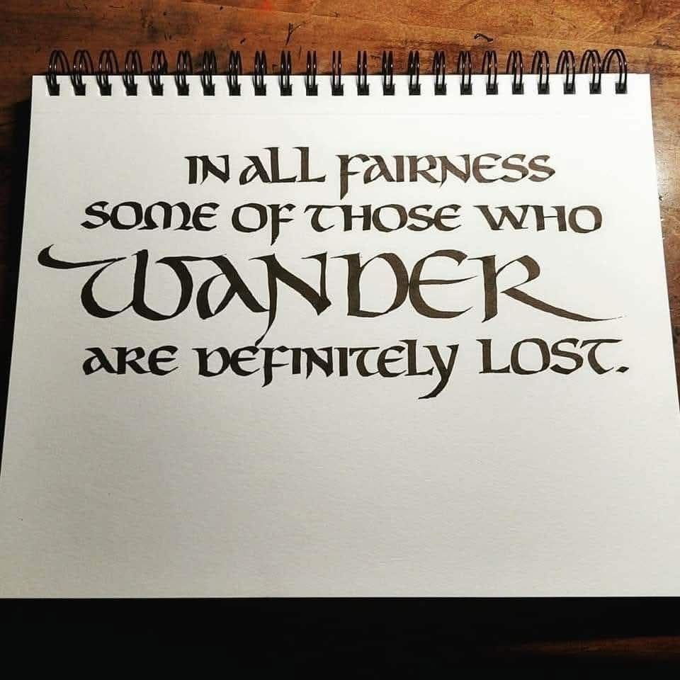 Lord of the Rings style font on a Bilbo's birthday party-style sign in a spiral bound sketchbook reads: In all fairness, some of those who wander are definitely lost.