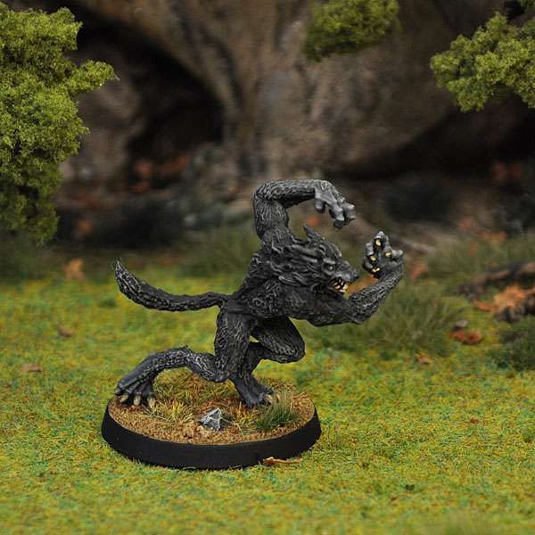 Werewolf miniature advancing from the edge of a model forest.