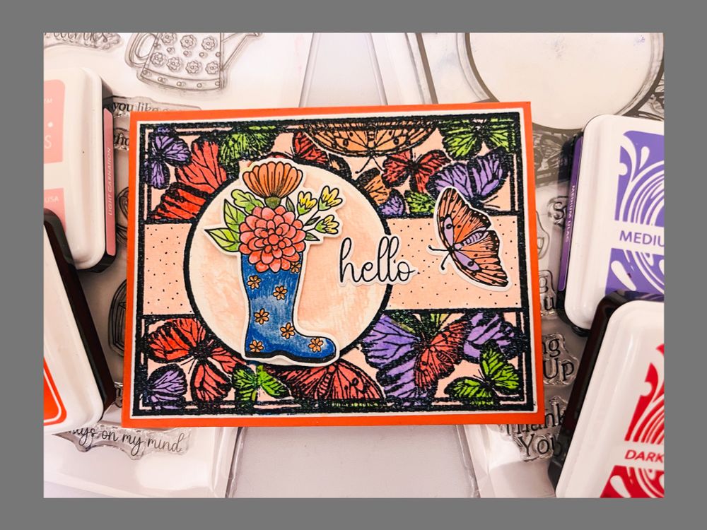 Card for spring with butterfly background and a boot with flowers in it. 