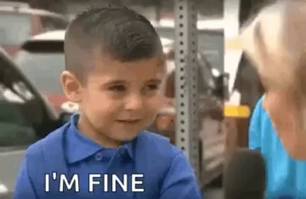 a young boy in a blue shirt is talking to a woman in a parking lot while holding a microphone .