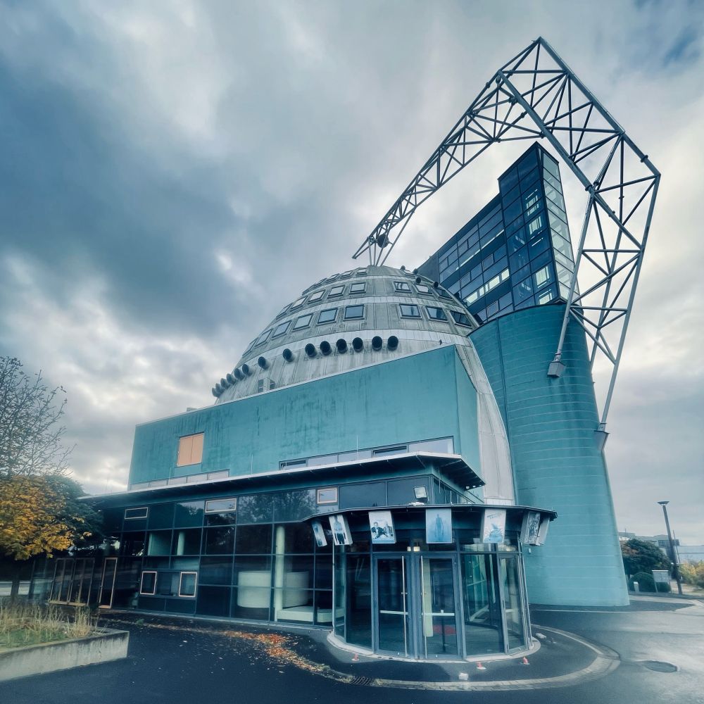 Außen Ansicht eines iMax Kinos mit herbstlichen Wolken.