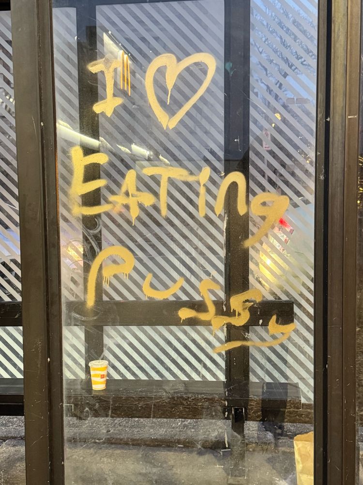 Graffiti on a bus stop that says “I ❤️ eating pussy”
