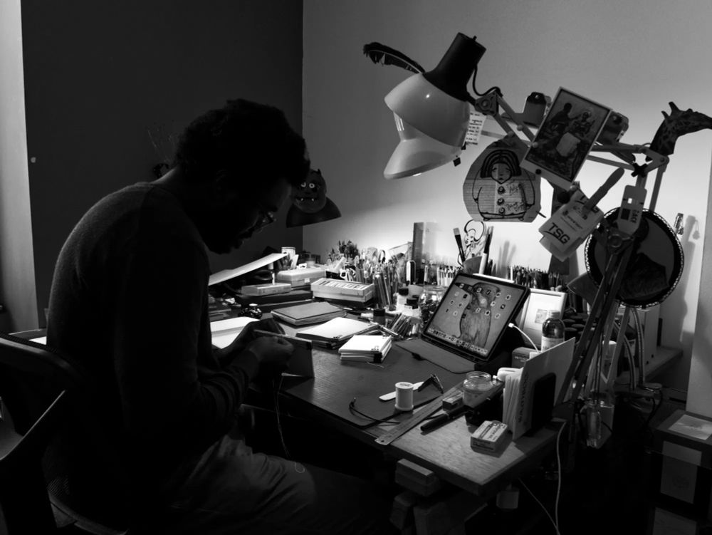 Adjim Danngar dans son atelier, fabriquant un carnet de croquis.