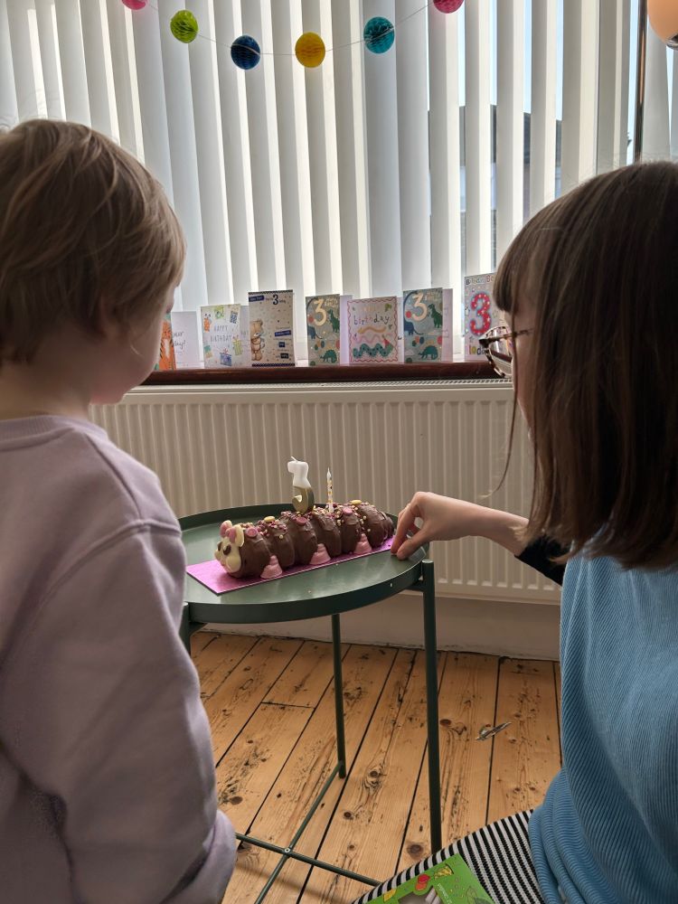 My son and I put candles in the top of a chocolate “Connie the Caterpillar” birthday cake 