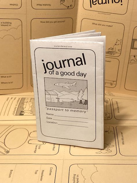 Image of a zine folded from a single sheet of white paper into an eight-page zine. It is resting on unfolded beige sheets of paper printed with the same content. The zine is titled "journal of a good day- passport to memory." A drawing of an airplane flying above a landscape with a house, trees, mountains, and an animal is present on the page.