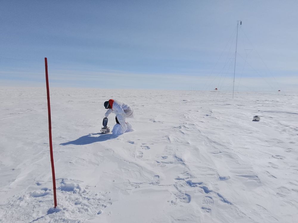 our PhD student Andrei sampling snow with a steel scoop at Concordia Station in Antarctica