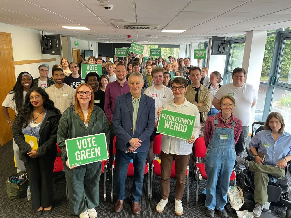 Indoor group photo of Anthony and a large number of Young Greens members holding up bilingual Vote Green boards.