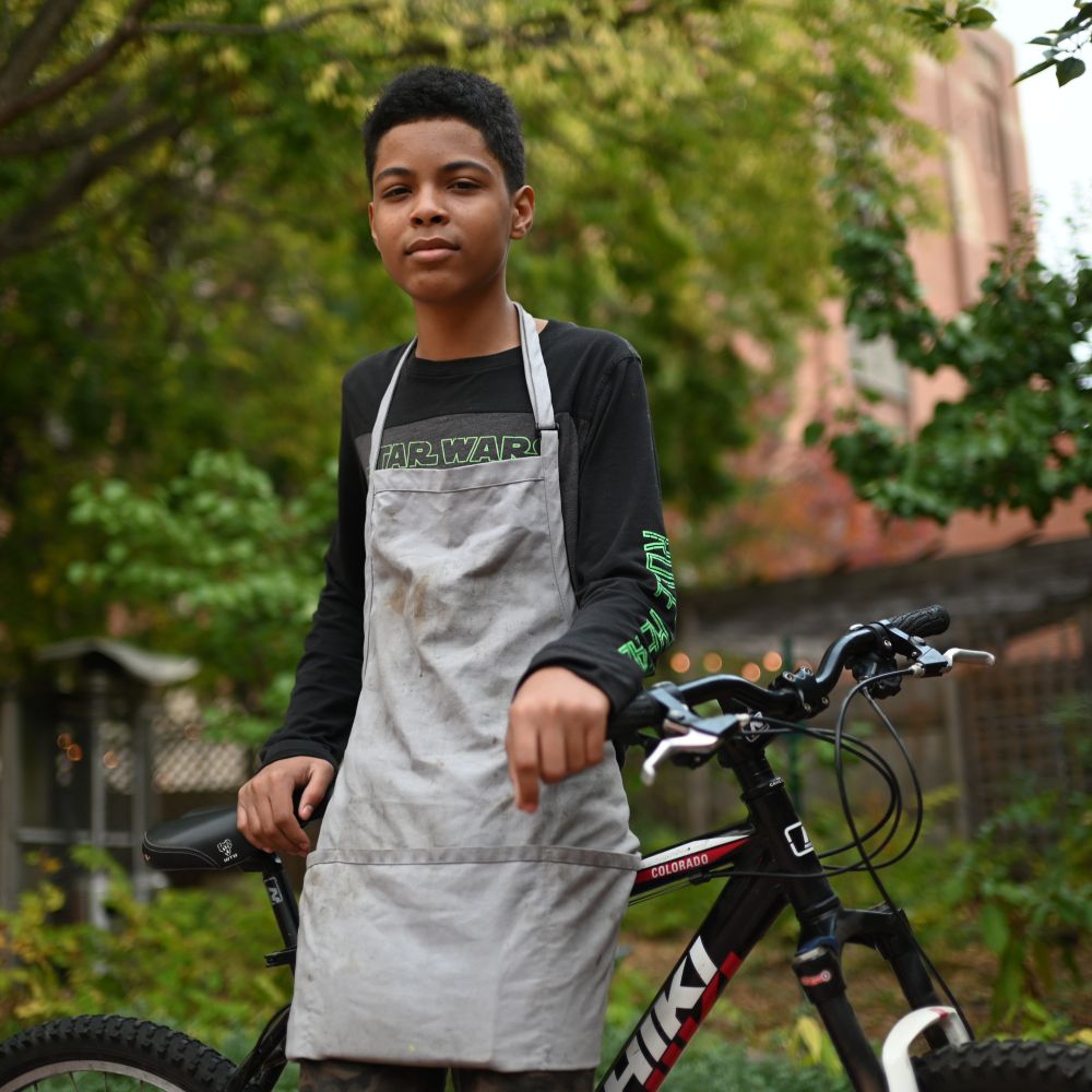 A closer shot of the same young man smiling gently with his black mountain bike.