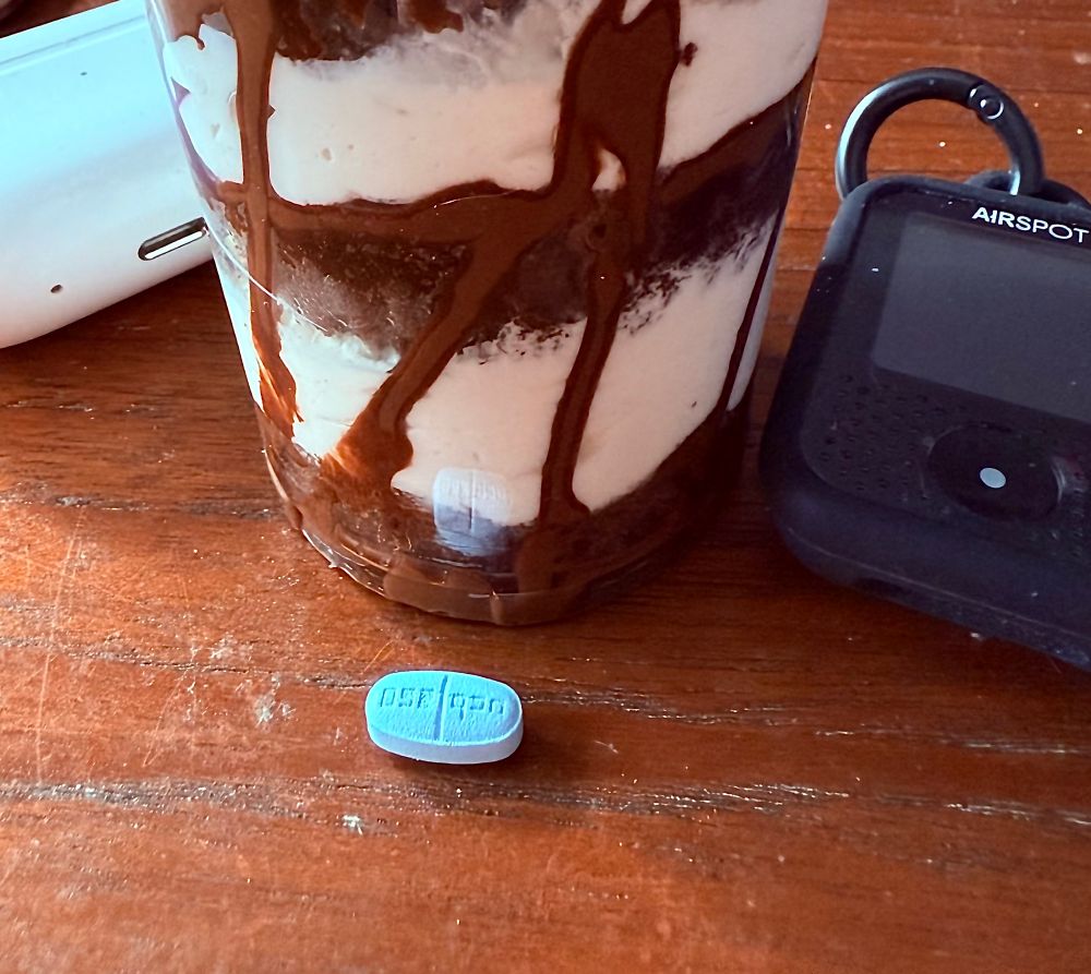 Keppra pill by a sundae, AirPods and Airspot CO2 monitor 