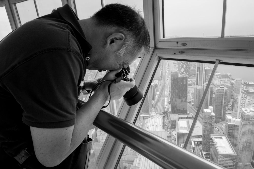 A photo of me (Asian man) taking a photo in Toronto’s CN Tower. 