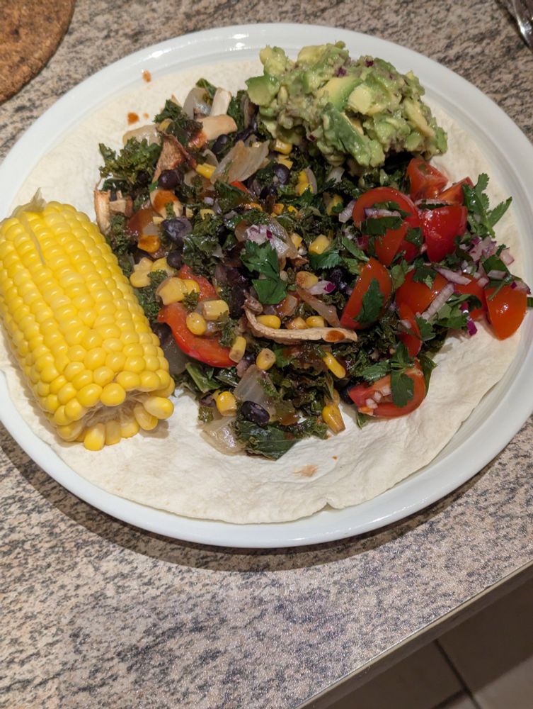 Mexican Kale including corn, black beans, onion, mushrooms and paprika. Served on a tortilla with Pico de Gallo, guacamole and a corn cob on the side. Recommended.
