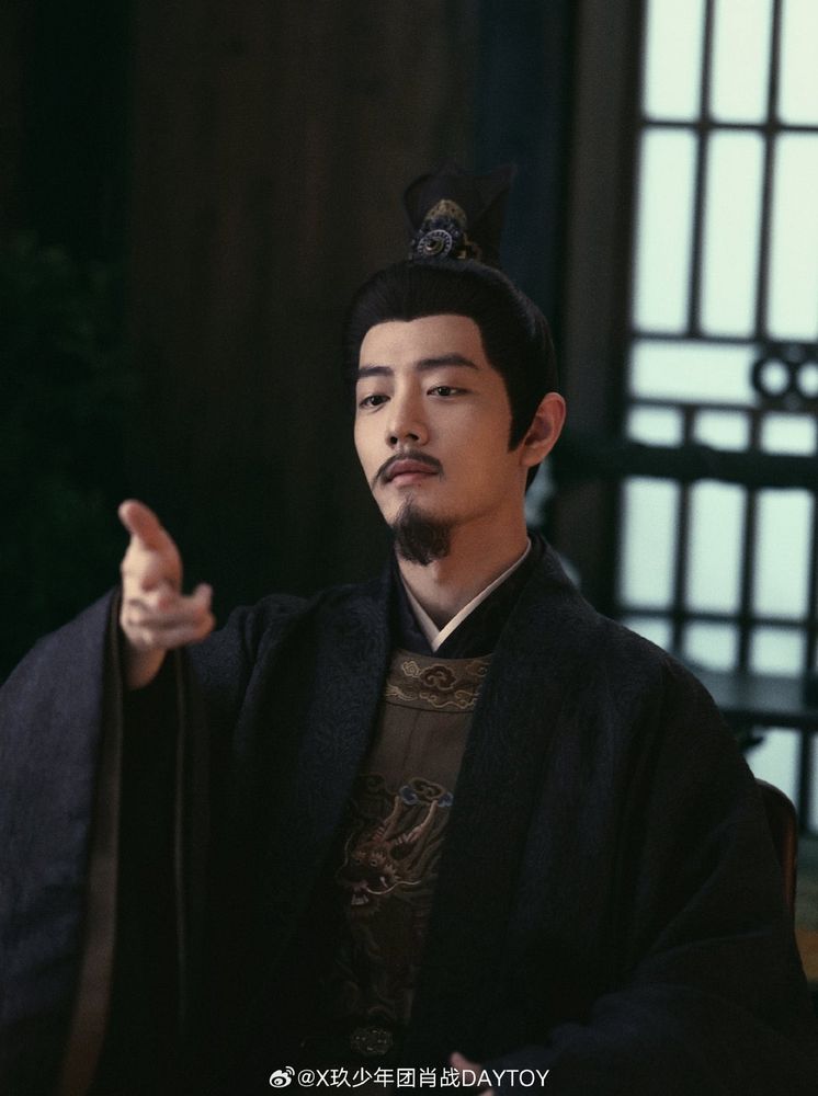 Xiao Zhan as Zang Hai holding his fingers as shooting with a gun