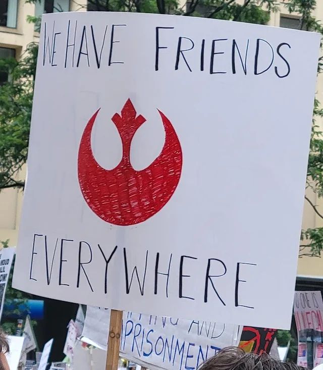 "We have friends everywhere" on a placard with an Andor symbol at the Chicago No Kings protest.