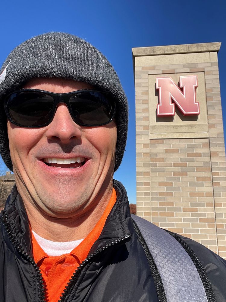 Dave standing under the University of Nebraska logo. That N stands for knowledge!