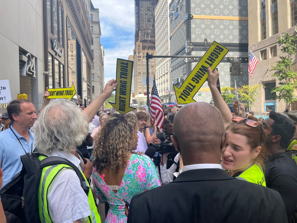 Trump Tower NYC, Workers over Billionaires protest. The Troll Patrol surrounds fake newscaster asking people shouting Hey, hey Ho, Ho Donald Trump has got to go, where do we want Trump to go?