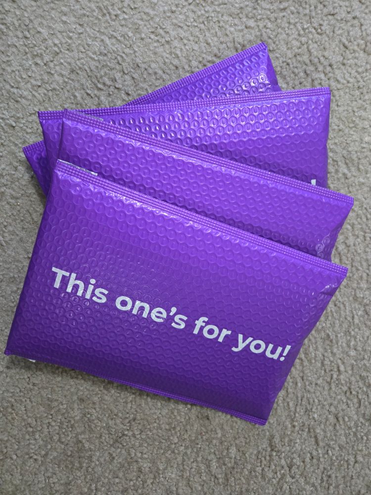 Purple mailers with signed books inside