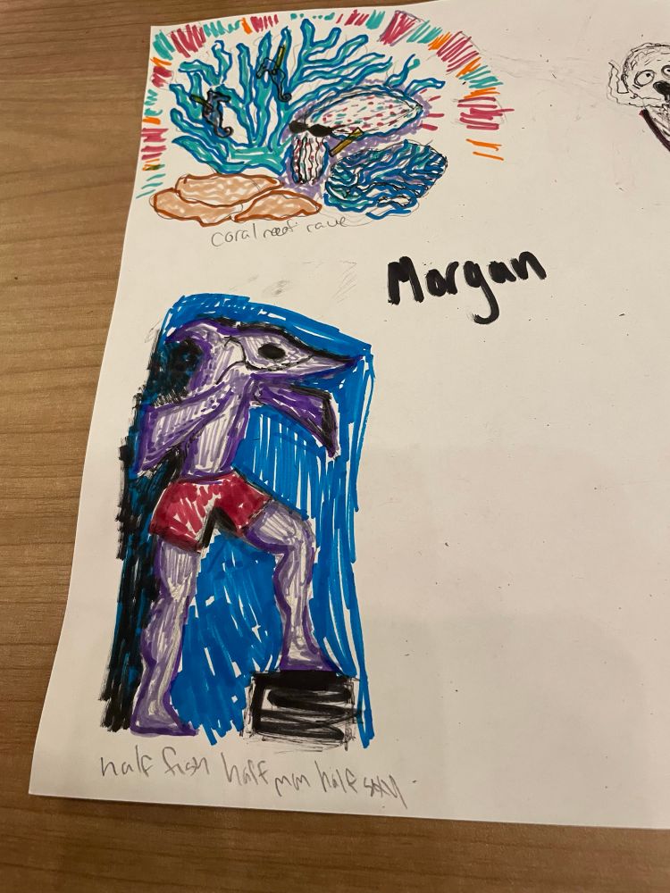 two marker drawings, one for the prompt “coral reef rave” starring some brain coral and fan coral and a cuttlefish, the other for “half fish half man half sexy”, showing a fish man with the top half of a chimaera wearing booty shorts 