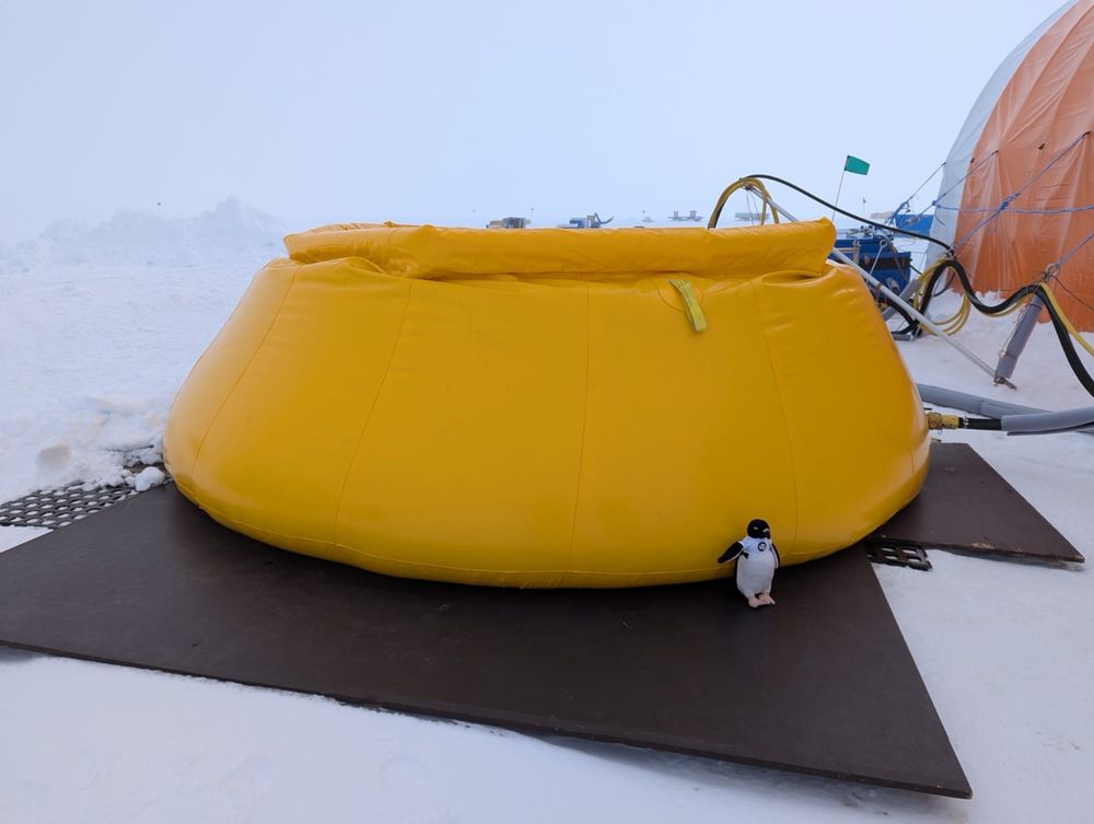 Adélie penguin chills by one of our two flubbers, which store the melted snow for hot water drilling. 
