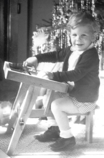 Little kid siting at his Christmas present peg-board. 