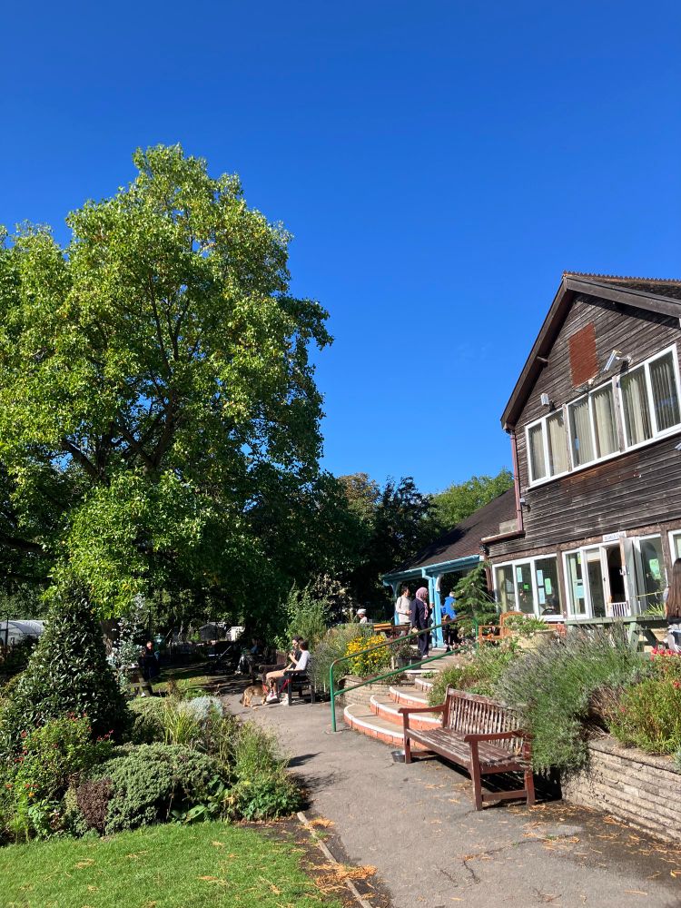 Blue skies above the community/centre cafe. Set in gardens with plenty of benches, flowers and shade.