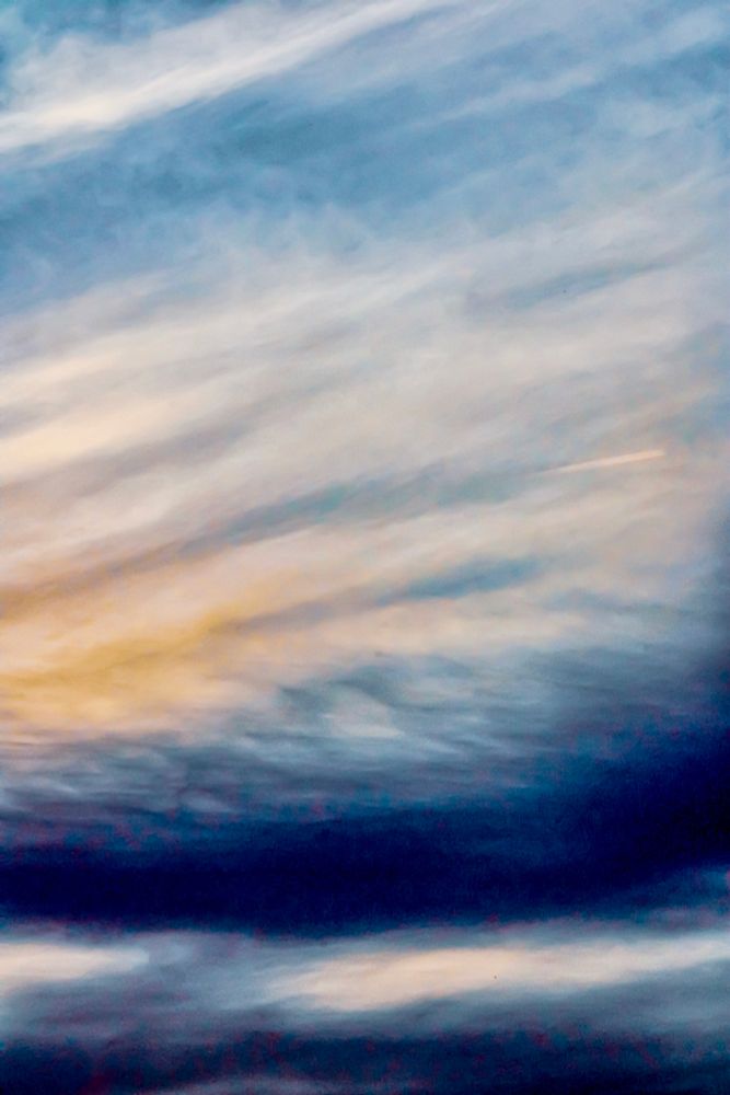 Cloudscape at sunset of vivid blues and gold running through wispy clouds.  Texture enhanced for prompt.  
