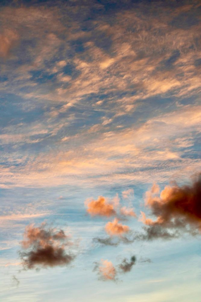 A textured mix of vibrant red cirrus and altocumulus clouds against the soft blues of sunset. August 19, 2025