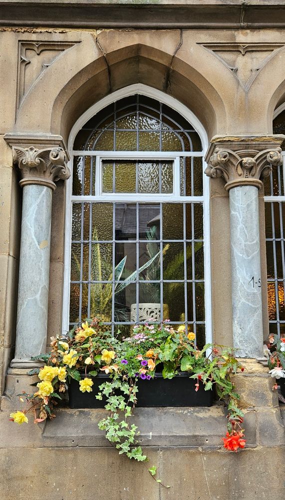 A windowbox, an arched shape window, columns. 