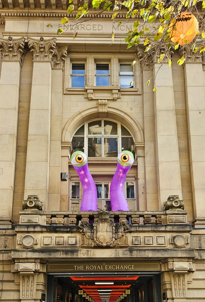 The front of a building decorated with a vibrant purple monster.