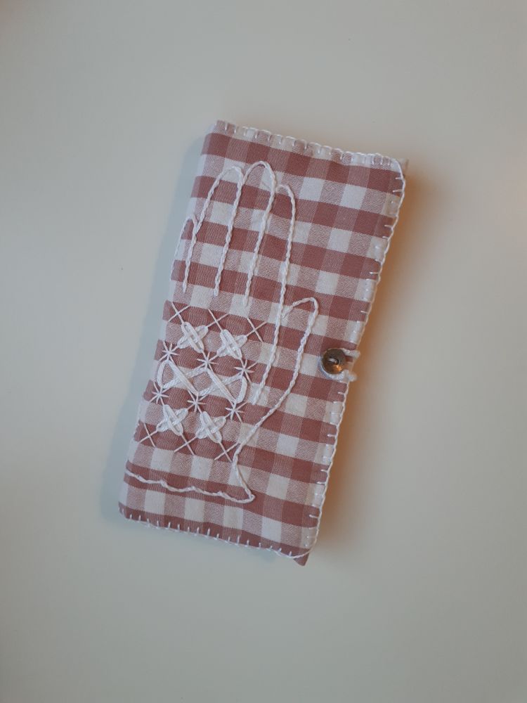 Porta-agulles rectangular fet amb tela vichy de color rosa i blanc, amb la figura d'uns guants brodats a l'exterior