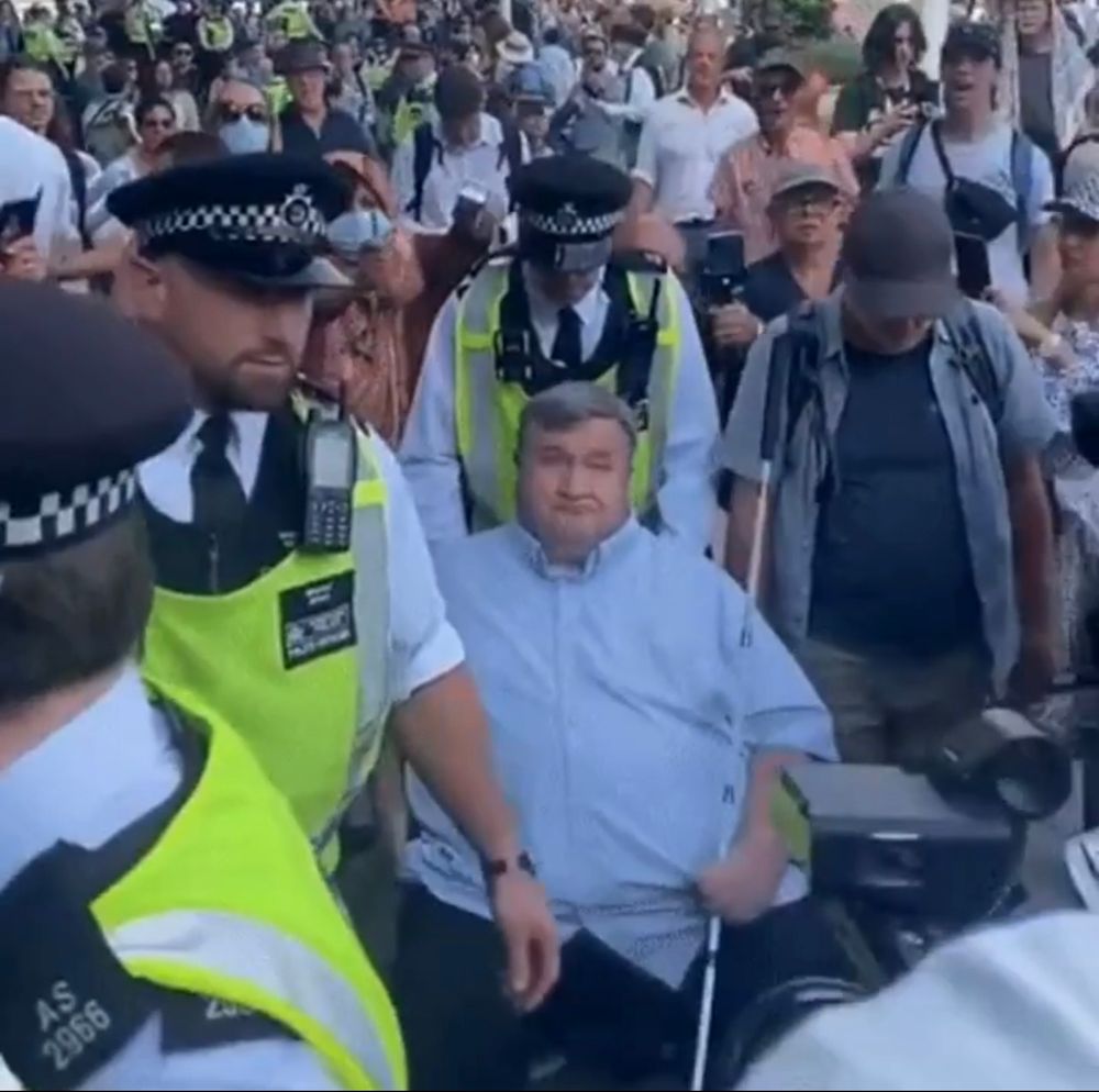 A blind man using a wheelchair arrested by police. 