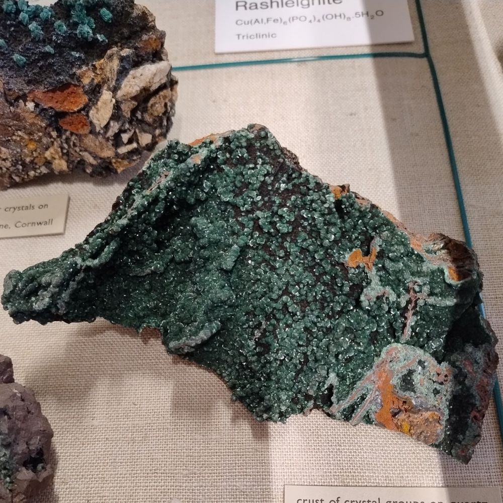 A crust of translucent light green chalcosiderite crystals with a rounded shape on rusty coloured quartz. From Phoenix Mine, Cornwall, England, UK.

Specimen on display in the Natural History Museum, London.
