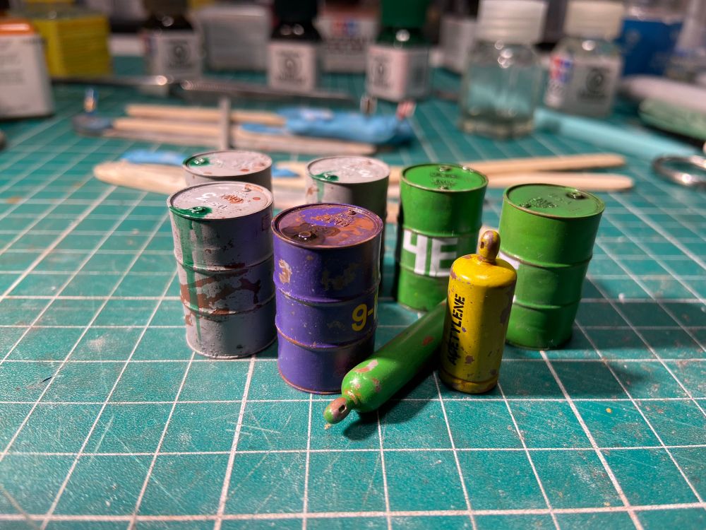 Scale model barrels and cylinders with dripping green fluid. 