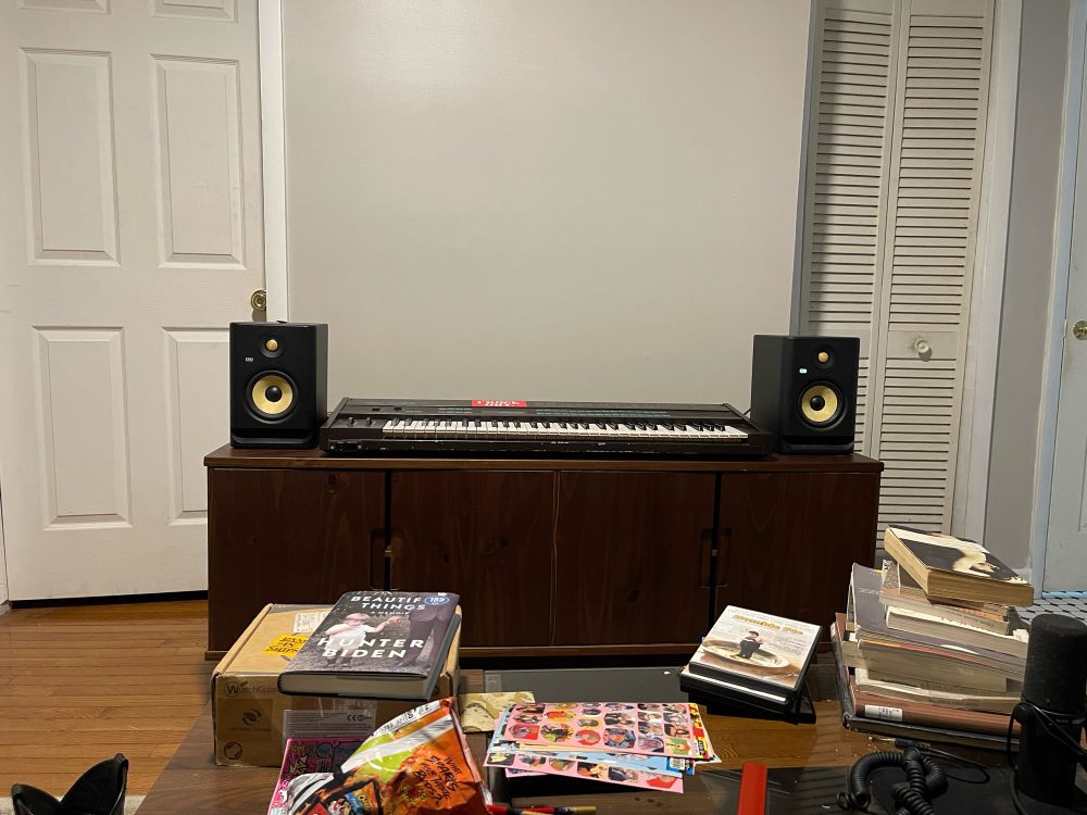 TV stand with speakers and a synth in the middle