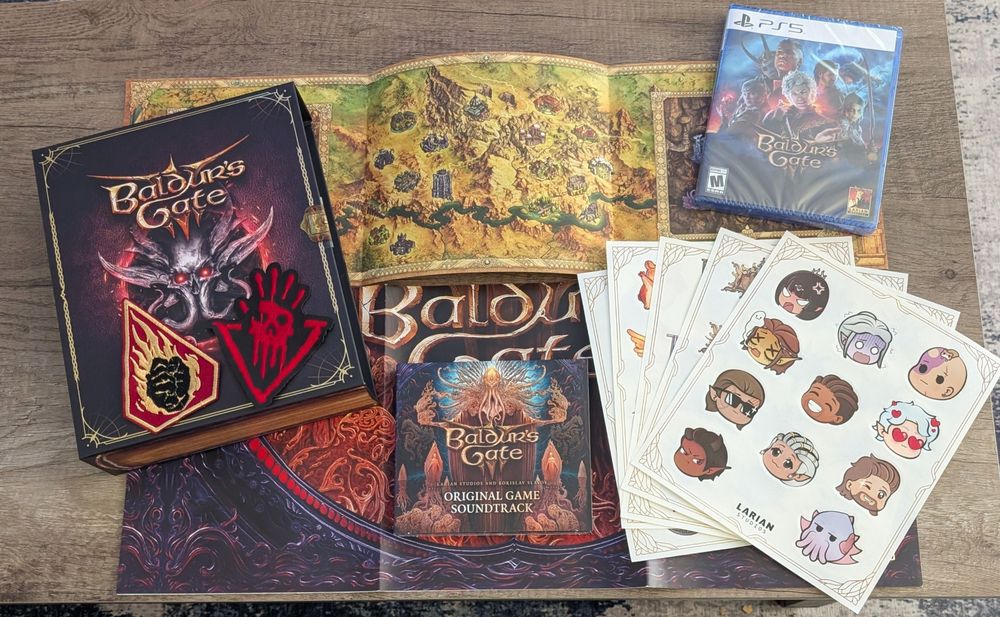 A photo of the Baldur's Gate 3 collector's edition, including the PS5 version of the game, the original game soundtrack, a poster of BG3 maps done in the style of older BG games, two patches (Flaming Fists symbol and Cult of the Absolute symbol), 5 sticker sheets that are stacked with the top sheet featuring chibi heads for the companions in the game, and box designed to look like a big tome, all displayed on a folded BG3 poster that's a much larger version of the soundtrack case cover. 
