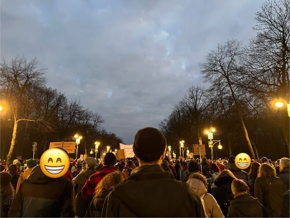 Demonstrierende auf der Hofjägerallee. Es wird dunkel, die Straßenlaternen sind bereits eingeschaltet.