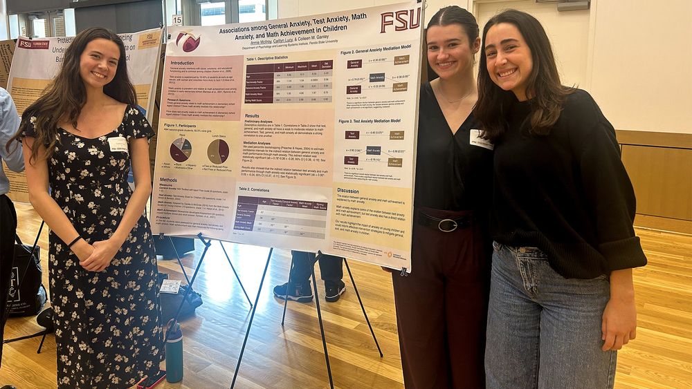 Caitlyn Lucy and Annie McIlroy pose with Christy Allen in front of their research poster.