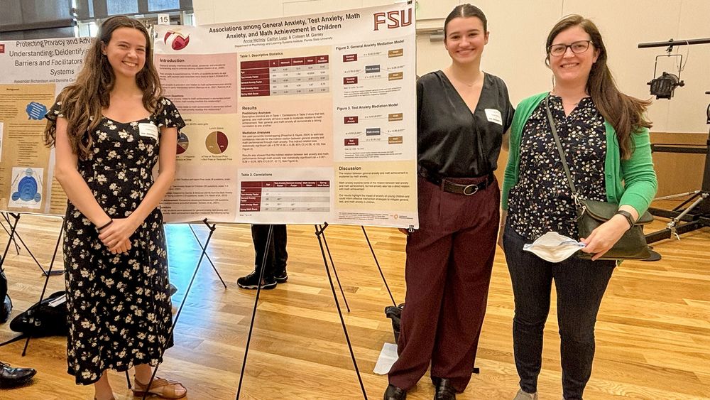 Caitlyn Lucy and Annie McIlroy pose with Dr. Colleen Ganley in front of their research poster.