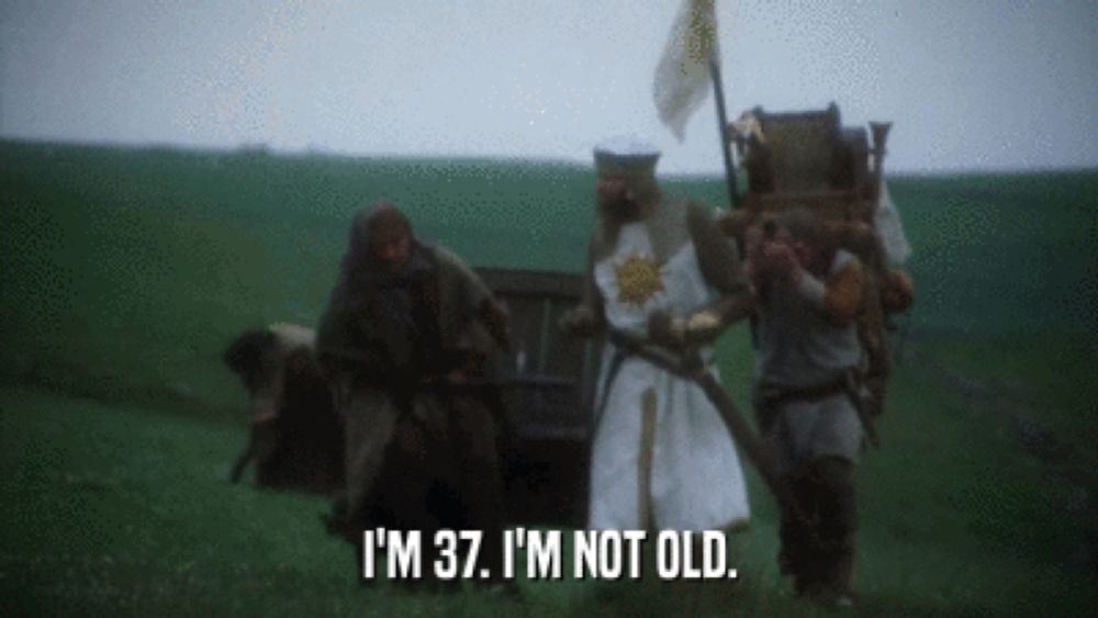 a group of men are standing in a field and one of them is saying " i 'm 37 i 'm not old "