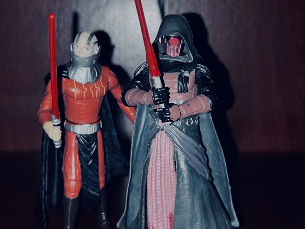 Darth Malak and Darth Revan action figures posed together. Both Sith Lords hold their red lightsabers forward. 