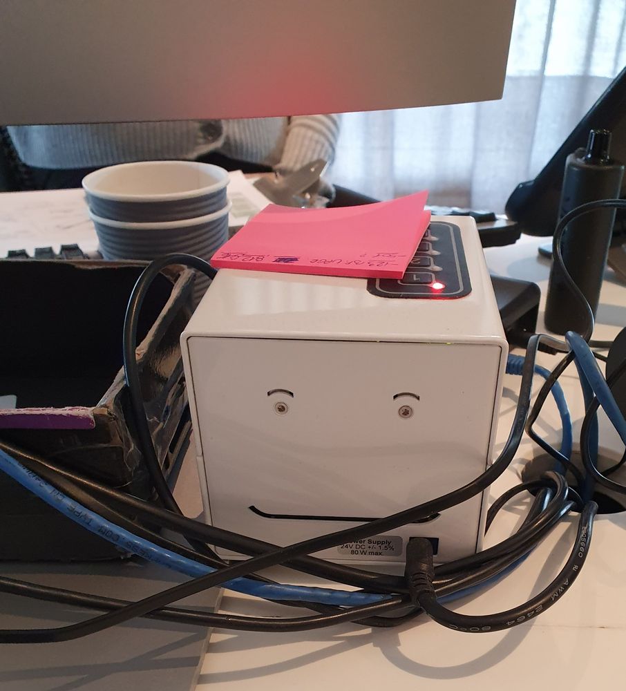 Computer switch box on desk. Air vents and screws resemble smiling face.