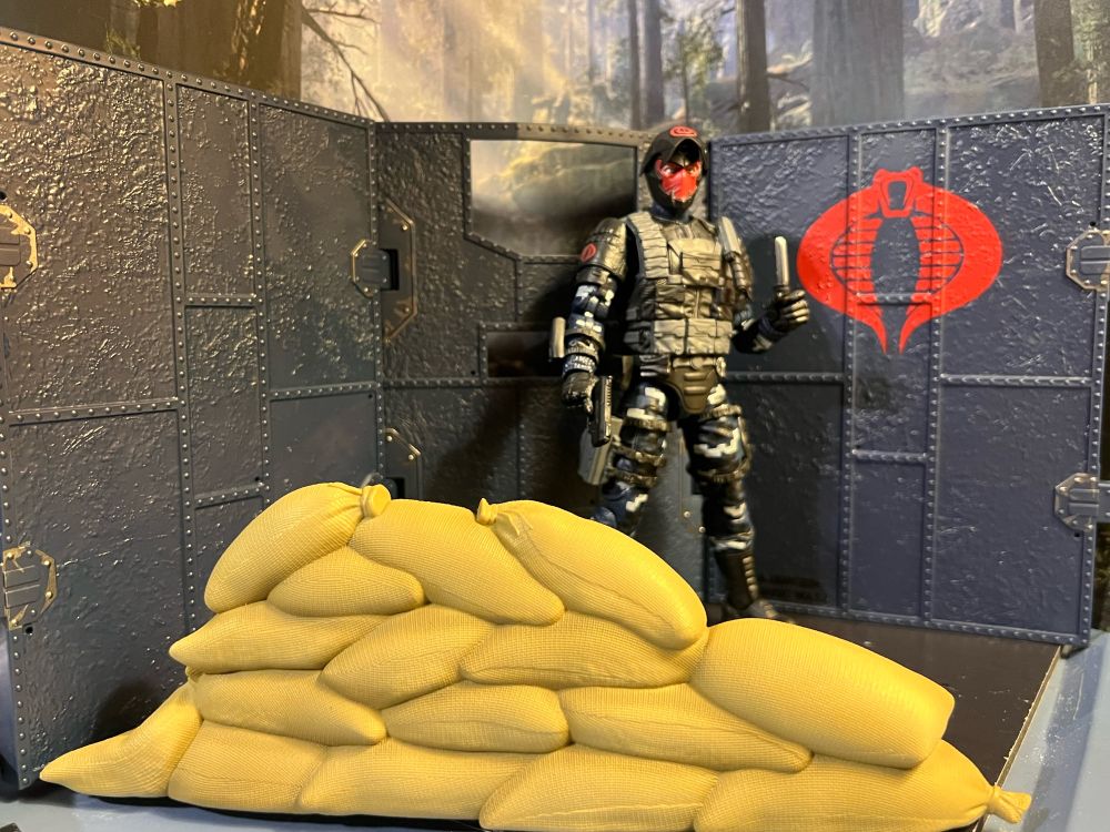 Trench Viper in front of a corner wall made from unfolding the bunker walls. Sandbags are piled up to become his ravioli fortress.