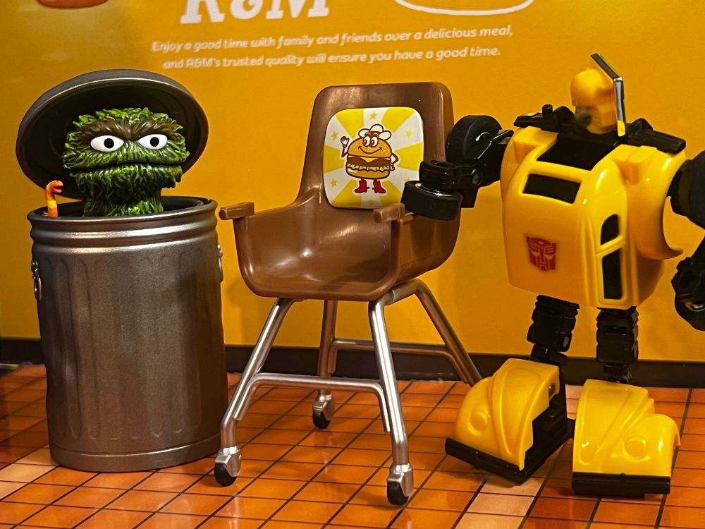 Bumblebee approaches a fast food high chair as Oscar watches