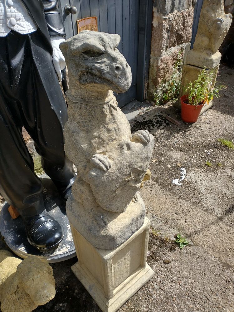 A grotesque stone carving holding a shield that bears a strong resemblance to uncle deadly from the Muppets.