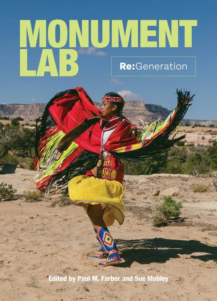 A young Diné woman in a red headband, red fringed cape, red and yellow skirt, and blue beaded boots with a starburst dances on a sandy walking path against a backdrop of trees and scrub with mesas in the distance. The Monument Lab – Re:Generation cover features Destiny Folgheraiter (Diné) at the Trail Opening Celebration from the Walking with Dinétah team. The photo was taken by Marissa Leshnov as a part of the Monument Lab Re:Generation initiative.