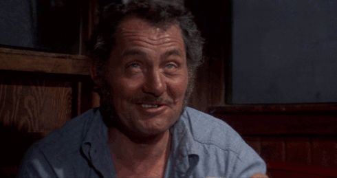 Quint from Jaws: "I'll never put on a life jacket again". Drinks from mug.
