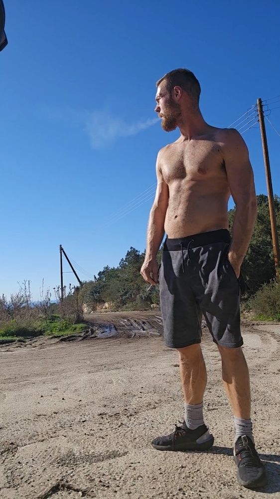 A young muscle bull smoking, takes a long hard draw and blows it all over you
