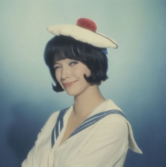 Anna Karina in a french sailor outfit winking at the camera 