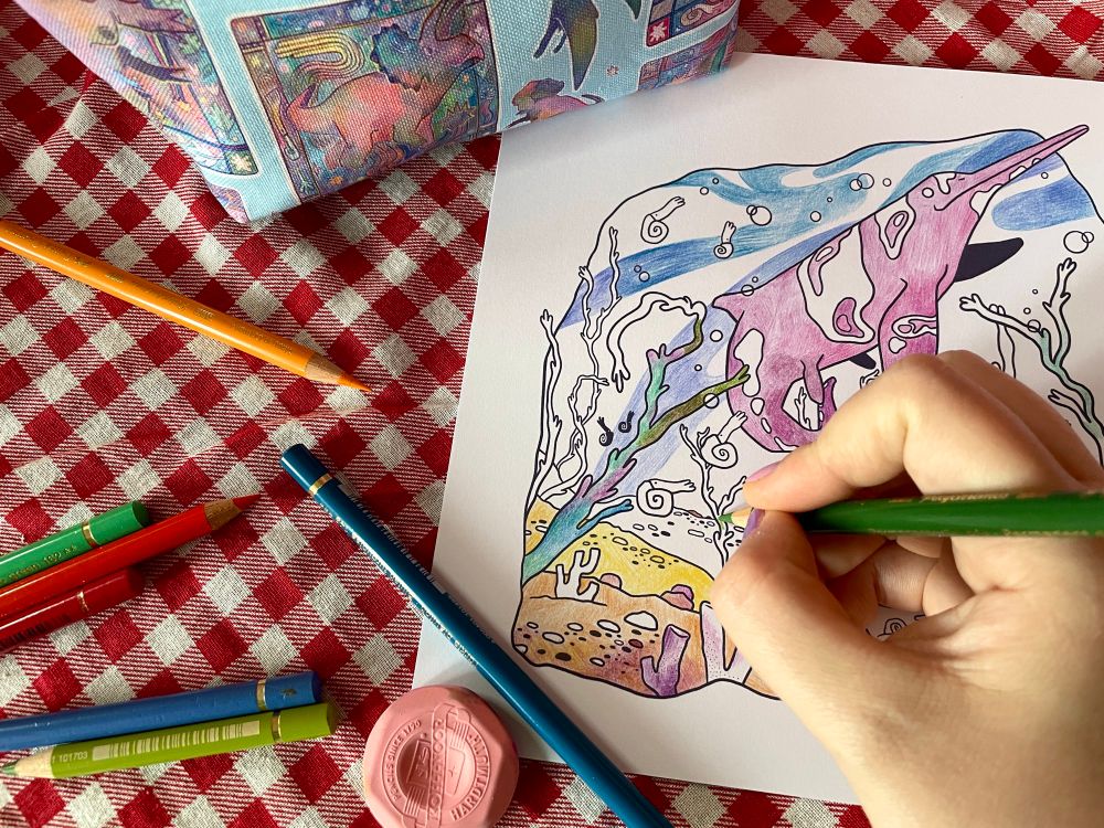 A progress picture of a colouring page atop a red gingham tablecloth 